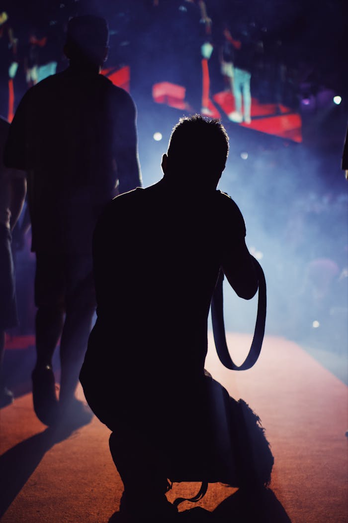 A talented photographer capturing a dynamic live music event, silhouette in vibrant colors.